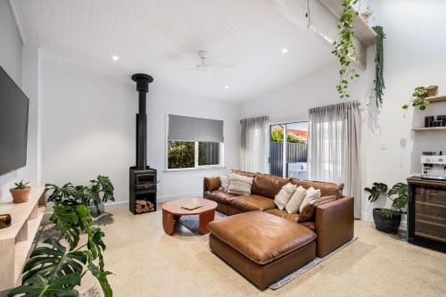 a living room with a couch and a stove at The Ausly Architectural Coastal Retreat with pool pet friendly in Aldinga Beach