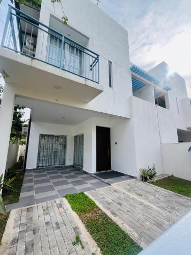 a white house with a patio in front of it at The Galene Villa By Celestial Ceylon in Negombo