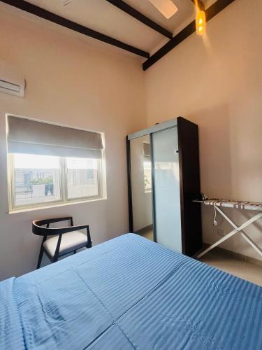 a bedroom with a bed and a window and a chair at The Galene Villa By Celestial Ceylon in Negombo