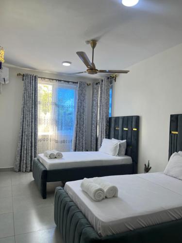 a bedroom with two beds and a window at Hidden gem-Nyali Vale Residence in Mombasa