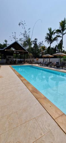 a swimming pool with blue water in a resort at Kingfisher House in Sangkhla Buri