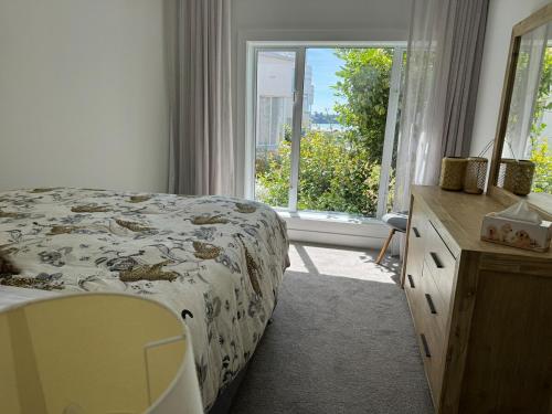 a bedroom with a bed and a large window at Bayview Apartment in Timaru
