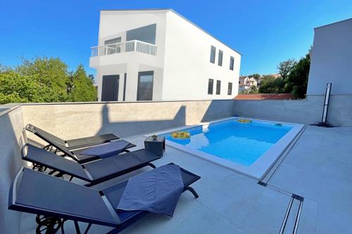 a patio with two chairs and a swimming pool at Apartment Bonum with Private Pool in Šilo