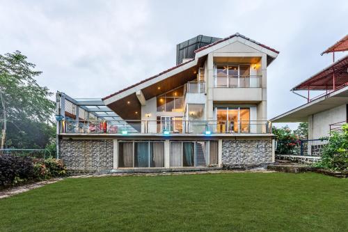 a house with a large yard in front of it at Gauri Villa by ELIVAAS With Pool, Lounge, Garden & Bathtub With 360 Panoramic Hill Views Near Waterfalls in Kasāra