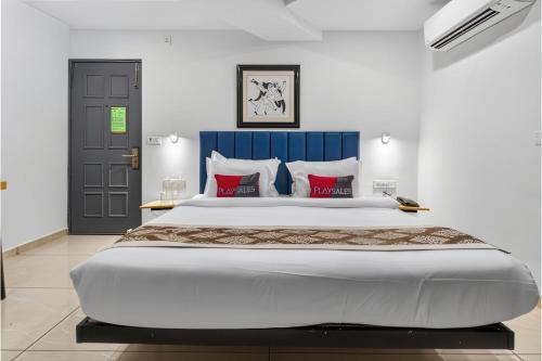 a bedroom with a large bed with red pillows at Rooms To Go - Indian Guest only in Vadodara