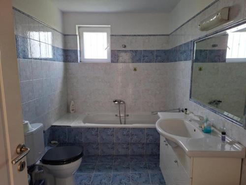a bathroom with a tub and a toilet and a sink at APARTMENT Sonia in Análipsis