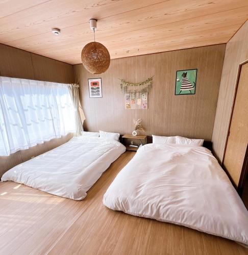 two beds sitting next to each other in a bedroom at 8 Guests Entire Private House in Gifu