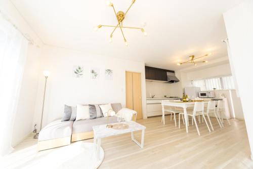 a white living room with a couch and a table at Miraie Yokkaichi Hazunaka in Yokkaichi