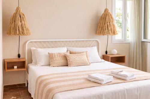 a bedroom with a white bed with two towels on it at Koralis in Petra