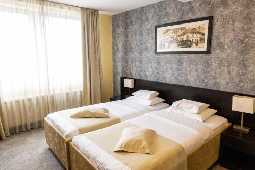 a hotel room with two beds and a window at Garni Hotel Nevski in Belgrade