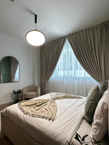 a bedroom with a large bed and a window at Grand Stay Holiday Homes Rental 2 in Dubai