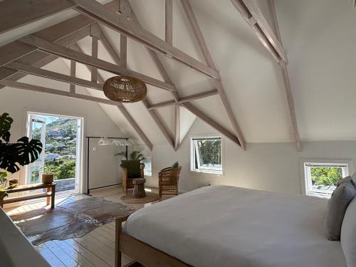 a bedroom with a large bed in a room with windows at 1 Fountain private pool in Hout Bay