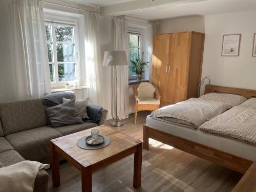 a living room with a bed and a couch and a table at Ferienhof Martens in Sörup