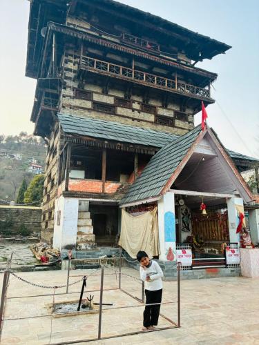 a person standing in front of a building at Suket homestay in Jhungi