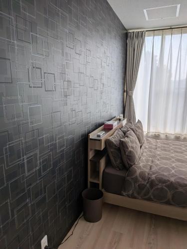 a small bedroom with a bed and a window at T&T Fujiyama MC2 in Iiyama
