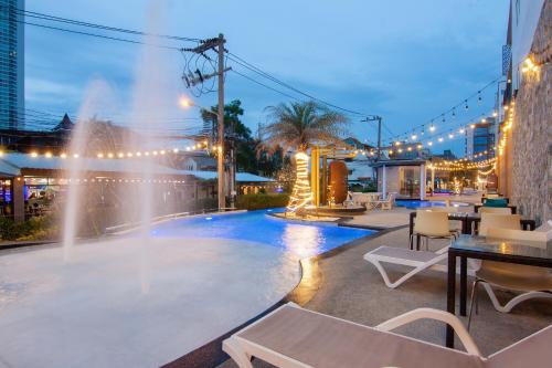 a pool with a fountain and tables and chairs at Golden Jomtien Beach Hotel in Jomtien Beach
