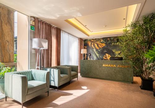 a hotel lobby with chairs and a painting on the wall at Amana Hotel Airport in Ho Chi Minh City