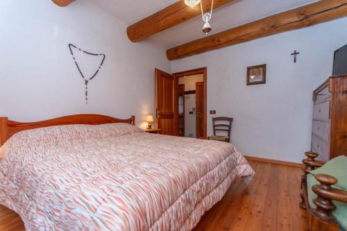 a bedroom with a bed and a tv on the wall at Tabia Maredane in Falcade
