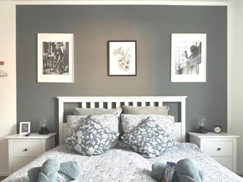 a bedroom with a bed with pictures on the wall at COZEE - Central Apartment with Netflix in Kaiserslautern