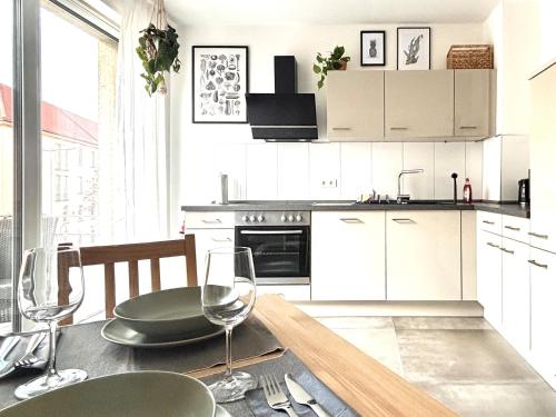 a kitchen with a table with wine glasses on it at COZEE - Central Apartment with Netflix in Kaiserslautern