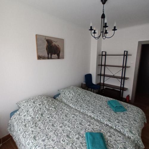 a bedroom with a bed and a picture of a cow at charming apartment in Stiring-Wendel