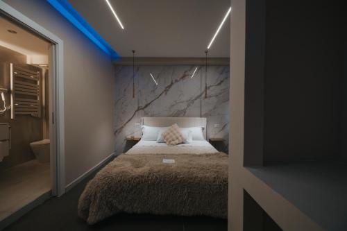 a bedroom with a bed with a stone wall at Artemide Suite Spa in Lido Di Fondi