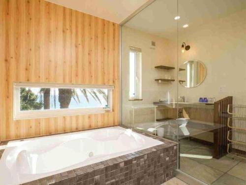 a large bathroom with a large tub and a window at VILLA YAHACHI GARDEN in Tahara
