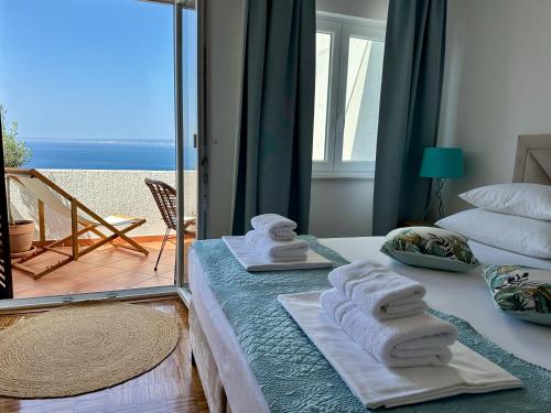 a bedroom with towels on a bed with a view of the ocean at Sunshine Residence in Stara Baška