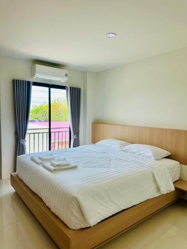 a bedroom with a large bed and a balcony at SK Residence & resort in Ban Nong Pla Mo