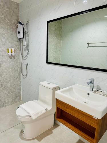 a bathroom with a sink and a toilet and a mirror at SK Residence & resort in Ban Nong Pla Mo
