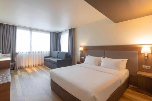 a hotel room with a bed and a chair at Campanile PRIME - Metz Centre Gare in Metz