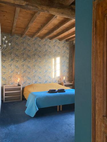 a bedroom with a bed in a room with blue walls at Gîte Asaliah in Sainte-Colome