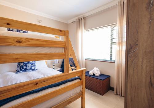 a bedroom with two bunk beds and a window at AllesWells in Yzerfontein