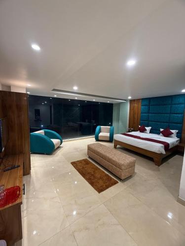 a large bedroom with two beds and a couch at Hotel Manoj in Bhopal