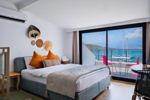 a bedroom with a bed and a view of the ocean at Körfez Apart in Fethiye