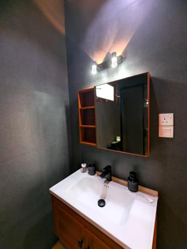 a bathroom with a sink and a mirror at White Tree Apartment in Bentota
