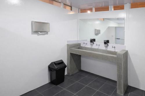 a bathroom with a sink and a trash can at Islanders Hostel Siquijor in San Juan