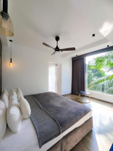 a bedroom with a large bed with a large window at White Tree Apartment in Bentota