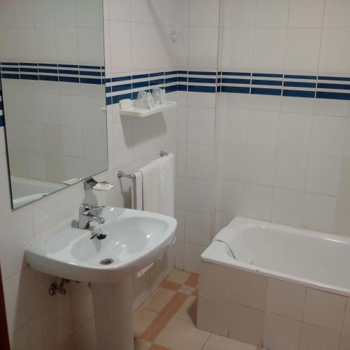 a bathroom with a sink and a tub and a toilet at Hotel Perú by Bossh! Hotels in Trujillo