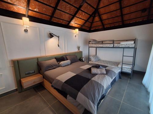 a bedroom with a bed and two bunk beds at Vidman Homey Huts in Tindummal