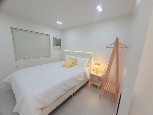 a white bedroom with a bed and a window at Stay Ali in Gyeongju