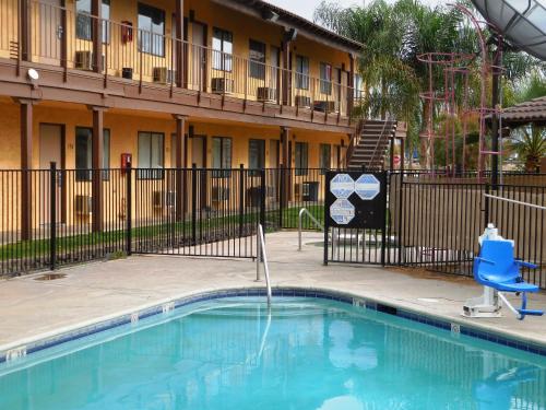 una piscina con una silla azul y un edificio en Best Economy Inn & Suites en Bakersfield