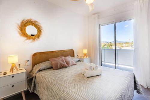 a bedroom with a bed with a large window at AT Ponent I B3 in La Playa de la Torre de Piles