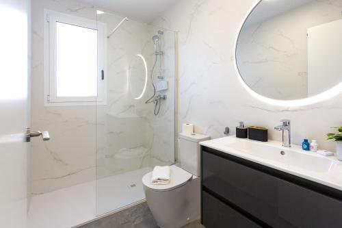 a bathroom with a toilet and a sink and a mirror at AT Ponent I B3 in La Playa de la Torre de Piles