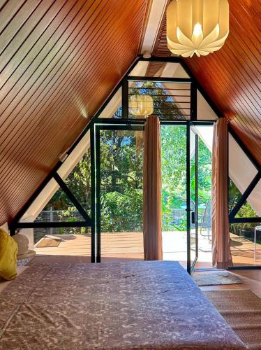 a bedroom with a bed and a large window at Jinjer Resort in Cavinti