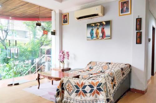 a bedroom with a bed and a table and a window at NamRoom at Margot Jaksa in Jakarta