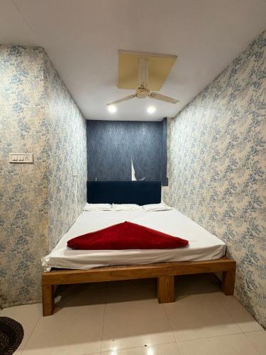 a bedroom with a bed with a red blanket on it at Shree Kulluka Guest House Ujjain in Ujjain