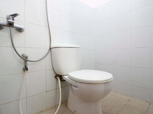 a white toilet in a bathroom with a shower at RedDoorz @ Seturan Raya in Yogyakarta