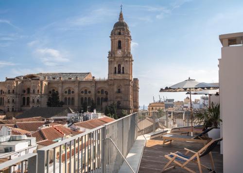 a balcony with a view of a building with a clock tower at Líbere Málaga Plaza del Siglo in Málaga