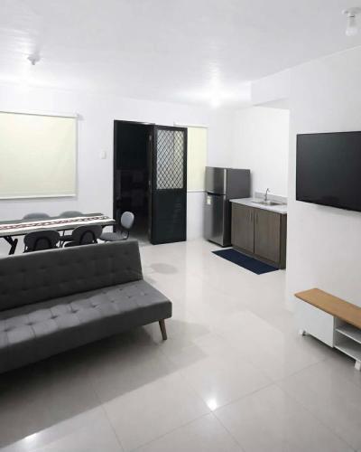 a living room with a couch and a flat screen tv at Ben & Ben - Unit 2 in Cebu City